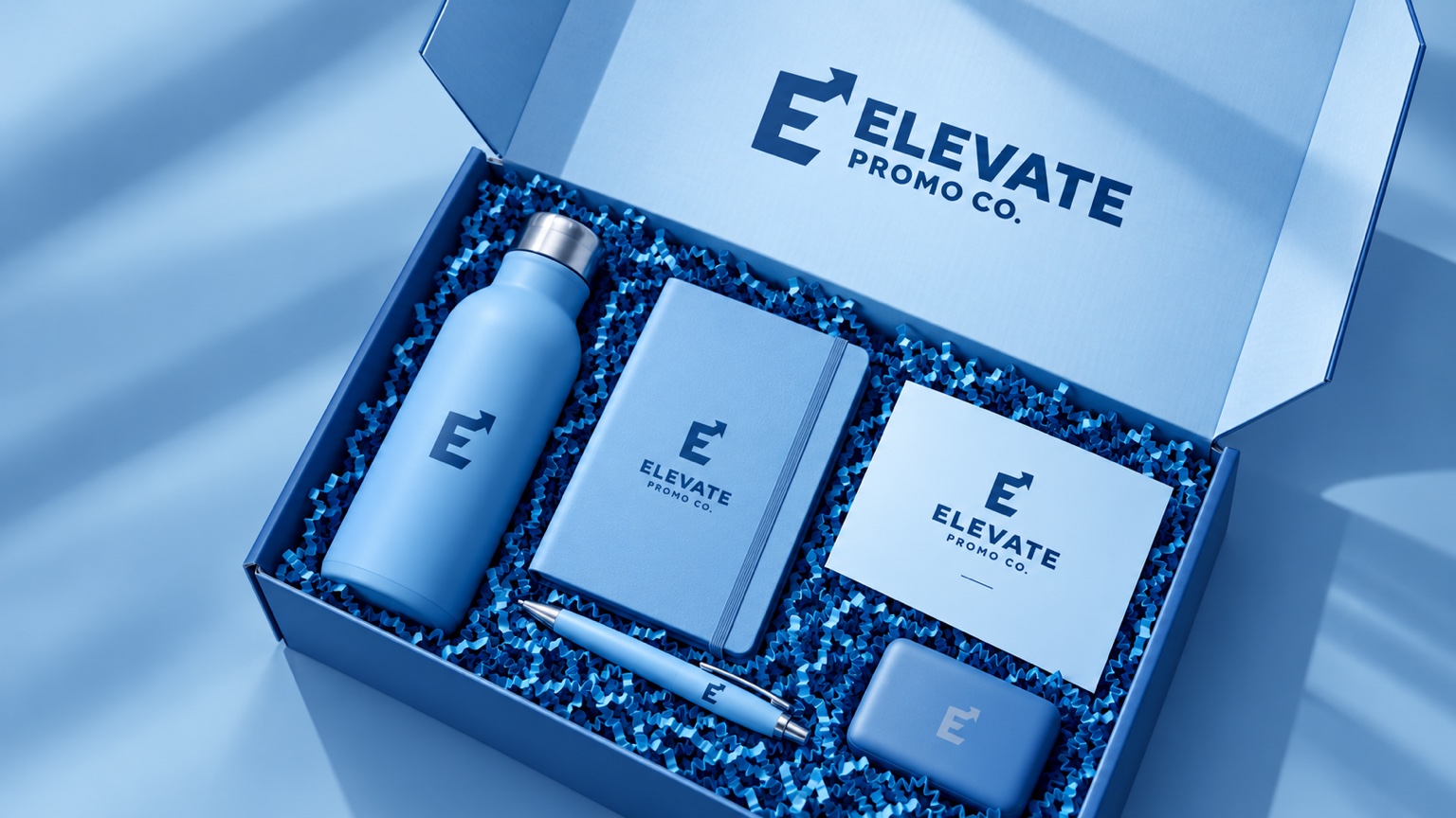 Coordinated blue gift box concept with a matching bottle, notebook, pen, and accessories
